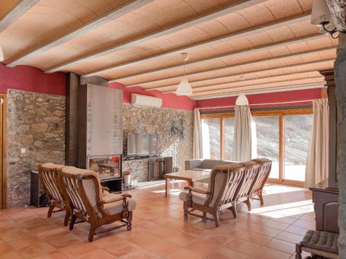sala de estar con mesa, sillas y chimenea en Aiguabella - Allotjaments Rurals, en Sant Feliu de Pallerols