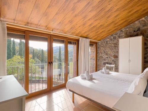 a bedroom with a bed and a large window at Aiguabella - Allotjaments Rurals in Sant Feliu de Pallerols