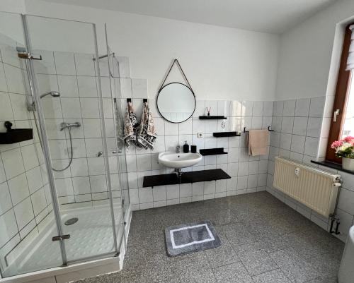 a bathroom with a shower and a sink and a mirror at Ferienwohnung am Markt in Kirchberg