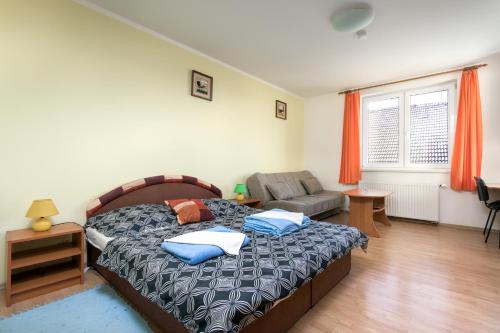 a bedroom with a bed and a couch at Penzion Zelený Dvor in Veľká Lomnica