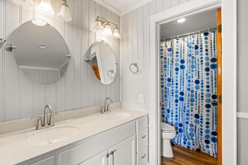 a bathroom with a sink and a toilet and a mirror at QB1- Michele's Seashell in Nags Head