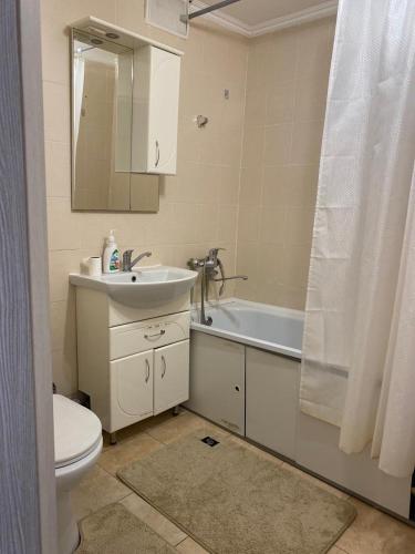 a bathroom with a sink and a toilet and a mirror at 2кмн Квартира по проспекту Республики 8 in Astana
