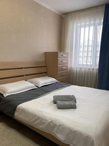 a bedroom with a bed with two towels on it at 2кмн Квартира по проспекту Республики 8 in Astana