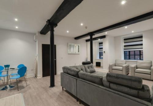 a living room with a large couch and a table at Temple Court Cavern Quarter Apartments in Liverpool
