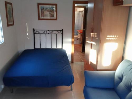 1 dormitorio con 1 cama azul y 1 sofá en Seminario Cottage, en Tortosa