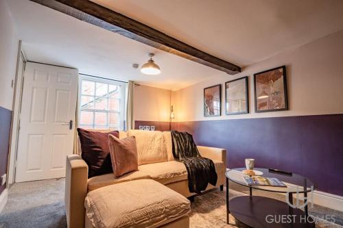 a living room with a couch and a table at Guest Homes - Chandan Court Apartment in Bewdley