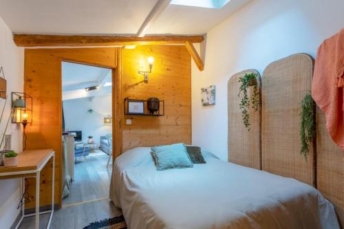 une chambre avec un lit et un bureau dans l'établissement Chartreuse, clim, parking, terrasse au calme, à Toulouse