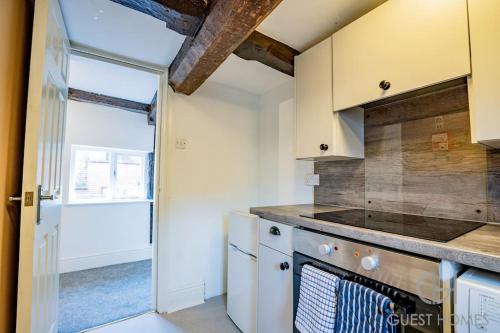 a kitchen with a stove top oven next to a door at Host & Stay - Chandan Court Apartment in Bewdley