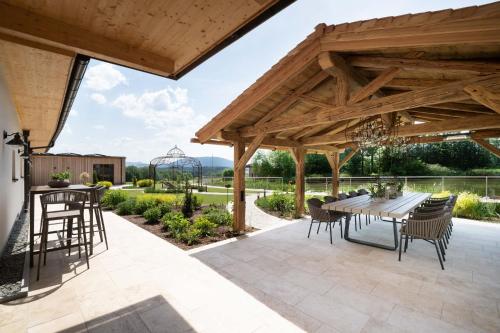 a wooden pavilion with a table and chairs on a patio at Rosenhof Salzburger Seenland in Strasswalchen