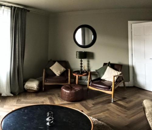 a living room with a table and chairs and a mirror at Auld Tom's Rest in St Andrews