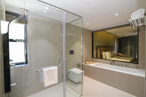 a bathroom with a shower and a toilet and a sink at ORIGIN BOUTIQUE HOTEL in Goa