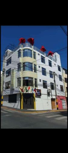 un gran edificio blanco con objetos rojos encima en Real Victoria en Ilo