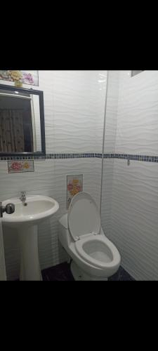 a bathroom with a white toilet and a sink at Real Victoria in Ilo
