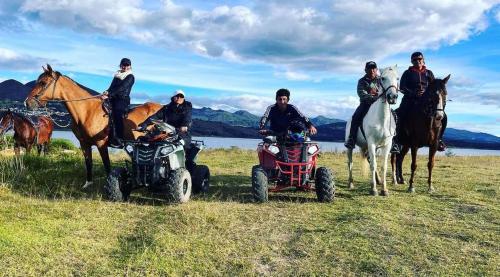 a group of people on atvs and horses in a field at Glamping blue. in Guatavita