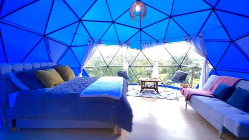 a blue room with a bed and a couch at Glamping blue. in Guatavita
