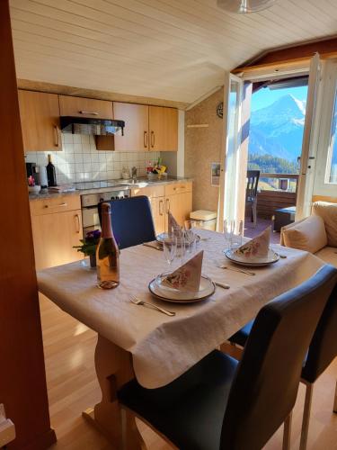 uma mesa de jantar com copos e uma garrafa de vinho em Chalet Lilo 2 Zimmer top mountain view em Beatenberg