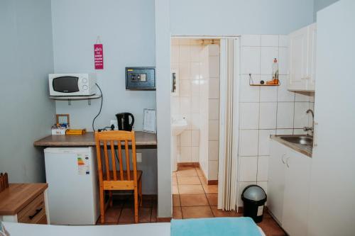 een kleine keuken met een wastafel en een koelkast bij Stay at 12 Guesthouse and Selfcatering in Middelburg
