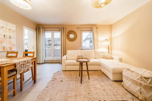 a living room with a white couch and a table at Beautiful apartment in the city and free parking in Luxembourg