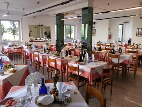 un ristorante con tavoli e sedie con tovaglie rosse e bianche di Hotel Nel Pineto a Montesilvano