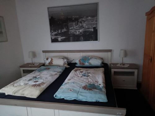 een slaapkamer met 2 bedden en 2 nachtkastjes bij Ferienwohnung an der Elbe in Bleckede