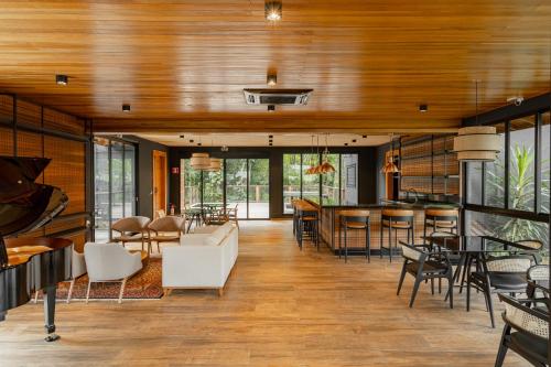 un soggiorno con soffitti e tavoli in legno e sedie. di LAS HOTEL BOUTIQUE a Foz do Iguaçu