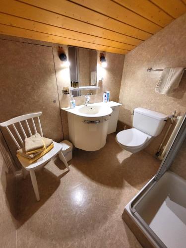 a bathroom with a sink and a toilet and a tub at Chalet Lilo 2 Zimmer top mountain view in Beatenberg