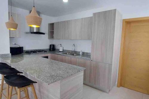 a kitchen with a counter and a island with bar stools at sunrise-villa-at-vistacana in Punta Cana