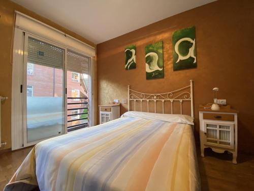 a bedroom with a large bed and a window at Casa La Dulce Olaya a pocos minutos de Oviedo 