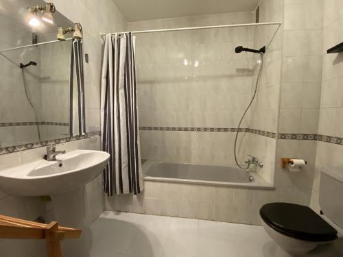 a bathroom with a sink and a toilet and a bath tub at Casa La Dulce Olaya a pocos minutos de Oviedo 