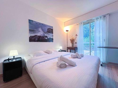 een slaapkamer met een groot wit bed en handdoeken bij New ! Terrasse Vue Mer - A 10min de Cannes in Le Cannet