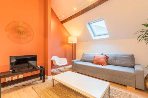 un salon avec un canapé et une télévision dans l'établissement Apartment in the heart of Old Lille, à Lille