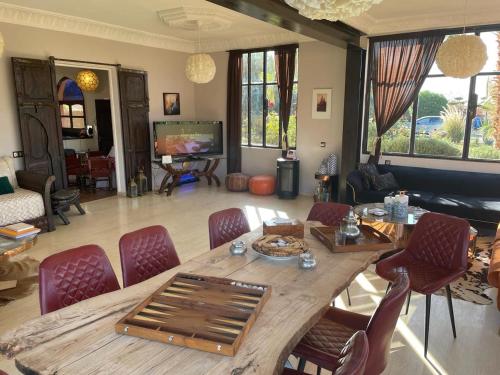 uma sala de estar com uma grande mesa de madeira e cadeiras em Kech-Montana 
