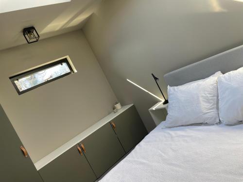 a small bedroom with a bed with a window at Modern guest house. in Bergen