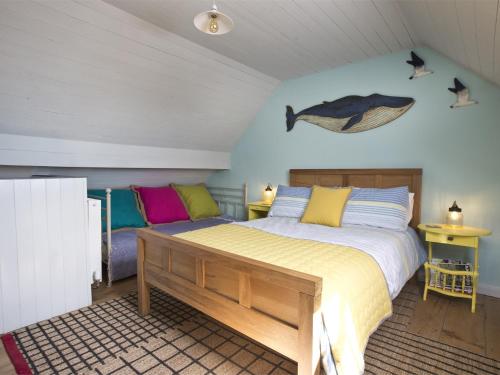 a bedroom with a bed and a fish on the wall at 2 Bed in Robin Hoods Bay G0085 in Robin Hood's Bay