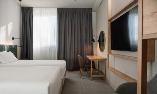 a hotel room with a bed and a television at Hilton Garden Inn Bologna North in Bologna