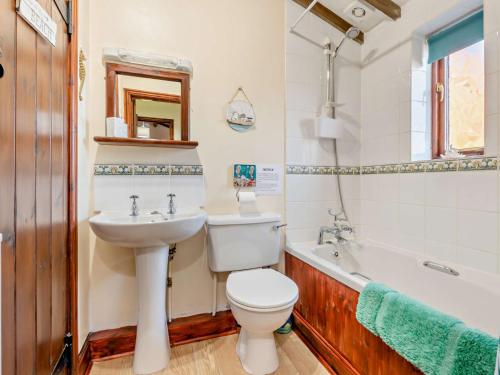 a bathroom with a toilet and a sink and a tub at 3 bed property in Tatterset 75673 in Tattersett