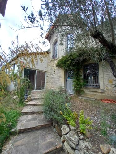 a house with a stone walkway in front of it at Aux quatre coins du monde in Champvoux