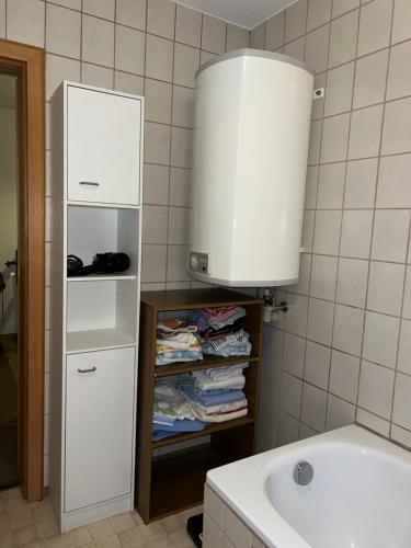 a bathroom with a sink and a shelf with towels at Haus Burga in Prackenbach