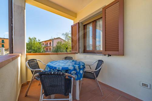 ein Tisch und Stühle auf einem Balkon mit Fenster in der Unterkunft Appartamenti Rosa Campo Mare - Goelba in Marina di Campo