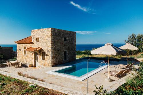 a house with a swimming pool next to the ocean at Gea Mani Villas in Agios Nikolaos