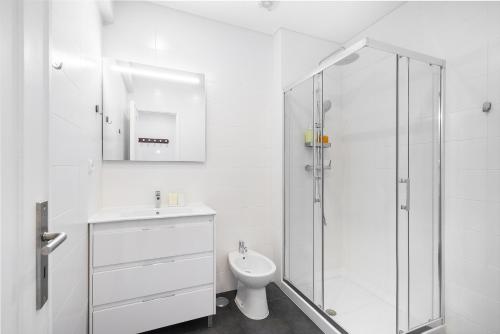 La salle de bains blanche est pourvue d'une douche et de toilettes. dans l'établissement WHome Peaceful Algés Family Home away from City Noise, à Algés