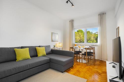 a living room with a gray couch and a table at WHome Peaceful Algés Family Home away from City Noise in Algés