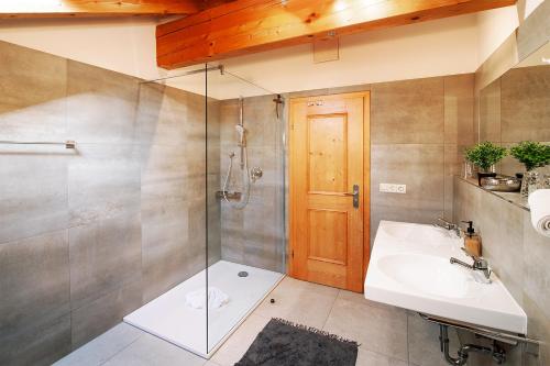 La salle de bains est pourvue d'un lavabo et d'une douche. dans l'établissement MyWinkl Design-Ferienwohnungen, à Reit im Winkl