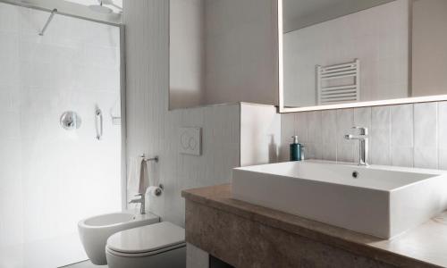 a bathroom with a sink and a toilet and a mirror at Hilton Garden Inn Bologna North in Bologna