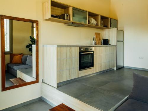 a room with a kitchen with a couch and a mirror at Gea Mani Villas in Agios Nikolaos