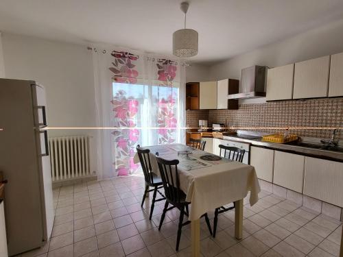 une cuisine avec une table et des chaises et une cuisine avec une fenêtre dans l'établissement Résidence Rose des Vents, à Jullouville