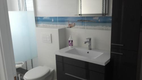 une salle de bain avec un lavabo et des toilettes dans l'établissement Appartement 6-8 personnes- 3 chambres- proche de tout à pied, à La Chaume