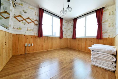 Pokój z drewnianymi ścianami i oknami oraz drewnianą podłogą w obiekcie Gyeongju Namu Guesthouse w mieście Gyeongju