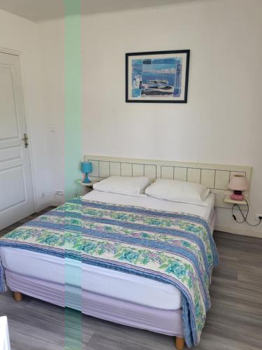 een slaapkamer met een bed met een quilt bij Résidence Rose des Vents in Jullouville-les-Pins