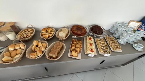 a table with many different types of breads and pastries at EL SHADDAI HOTEL in João Pessoa